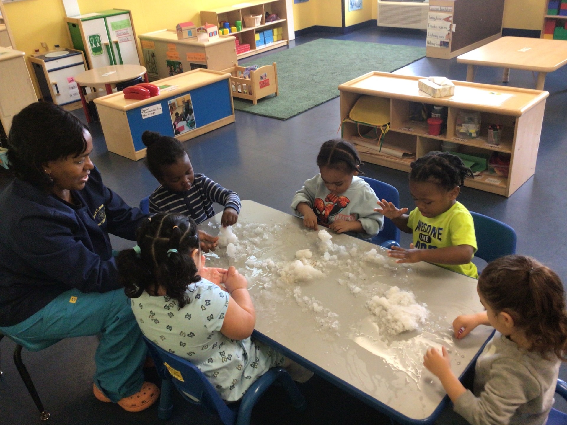 Children engaged in sensory play with cotton-like material at a table