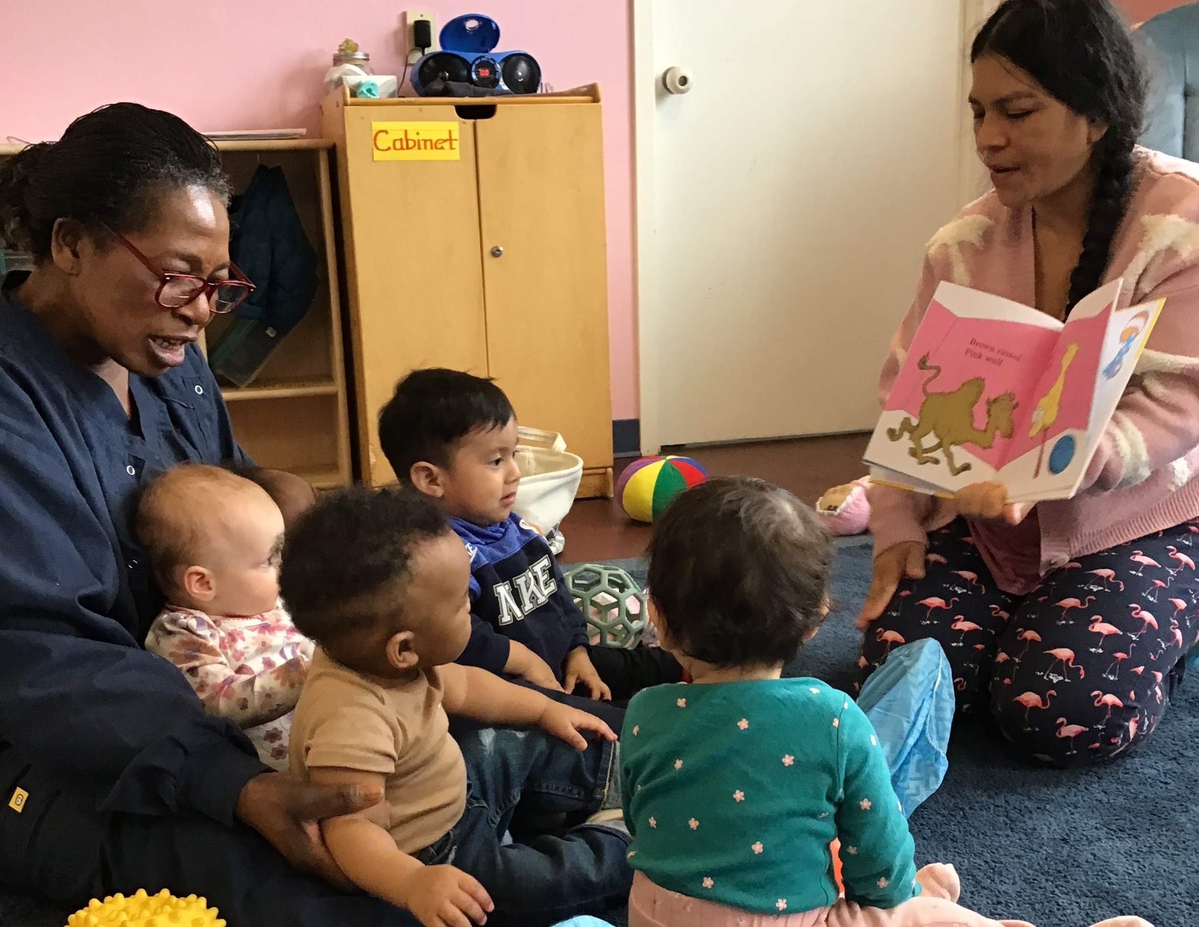 Parent reading a book to the children